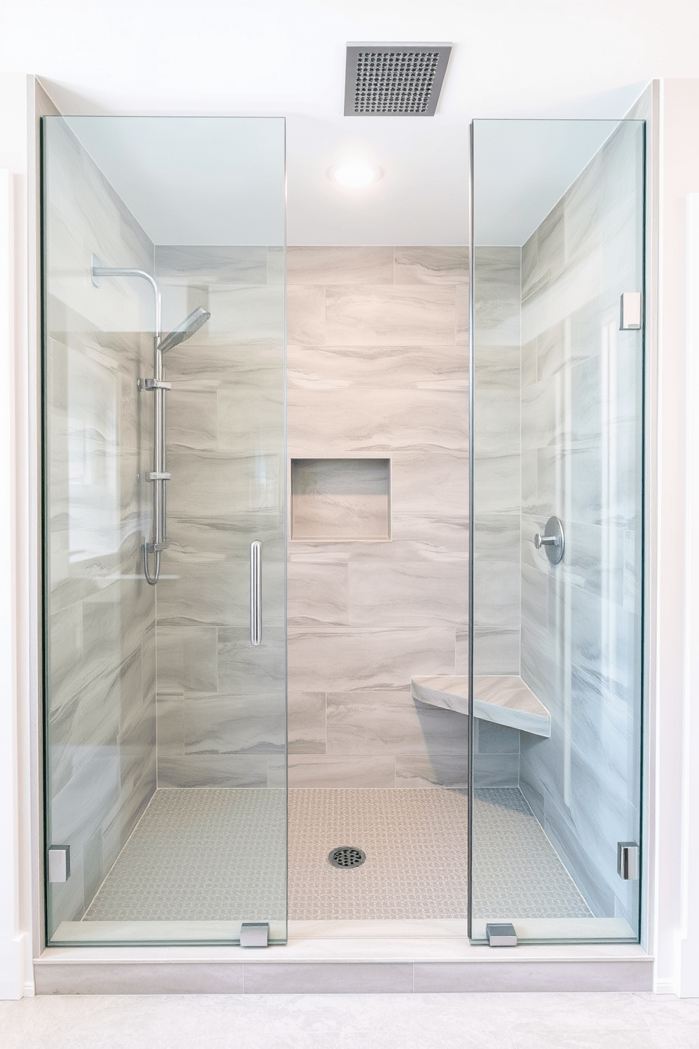 A modern walk-in shower design featuring a sleek glass enclosure that creates an open and airy feel. The shower is adorned with large format tiles in a soft gray color, complemented by a rainfall showerhead and a built-in bench for added comfort.