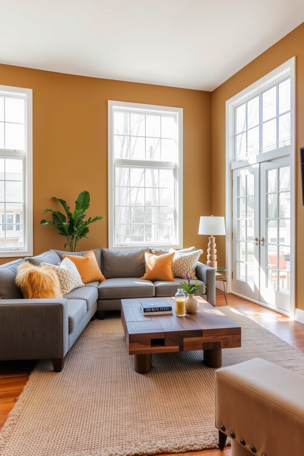 A cozy living room featuring muted mustard walls that create a warm and inviting atmosphere. The space is accented with a plush gray sofa and a statement coffee table made of reclaimed wood. Large windows allow natural light to flood the room, highlighting the textured area rug beneath the seating area. Decorative throw pillows in complementary colors add a touch of personality and style to the overall design.