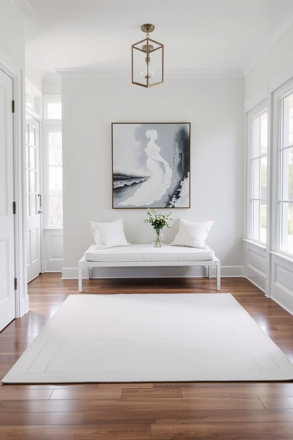 Chic white bench with plush cushions. The bench is positioned against a wall adorned with elegant artwork, creating a welcoming focal point in the foyer. White foyer design ideas include a light-colored area rug that adds warmth to the space. Natural light floods in through large windows, illuminating the airy atmosphere and highlighting the simplicity of the design.