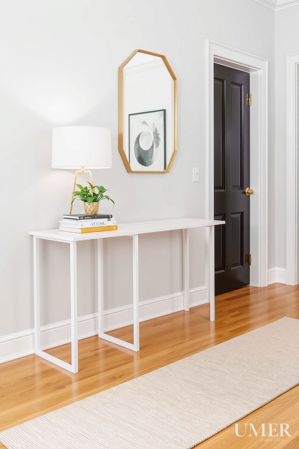 A stylish white side table is placed against a soft gray wall, adorned with a minimalist lamp and a stack of art books. A small potted plant adds a touch of greenery, creating a fresh and inviting atmosphere. The foyer features a sleek console table with a decorative mirror above it, framed in brushed gold. Warm wood tones in the flooring complement the white walls, while a chic runner adds texture and warmth to the entryway.