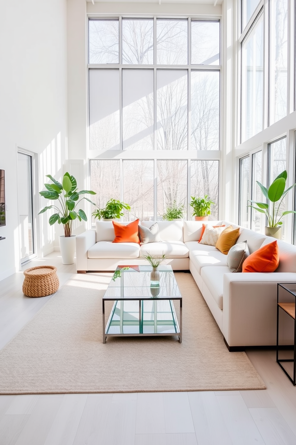 A bright and airy living room filled with natural light streaming through large floor-to-ceiling windows. The space features a plush white sectional sofa adorned with colorful throw pillows, complemented by a sleek glass coffee table at the center. The walls are painted in a soft white hue, enhancing the room's openness and brightness. A large area rug with subtle patterns anchors the seating area, while indoor plants add a touch of greenery and vibrancy to the design.