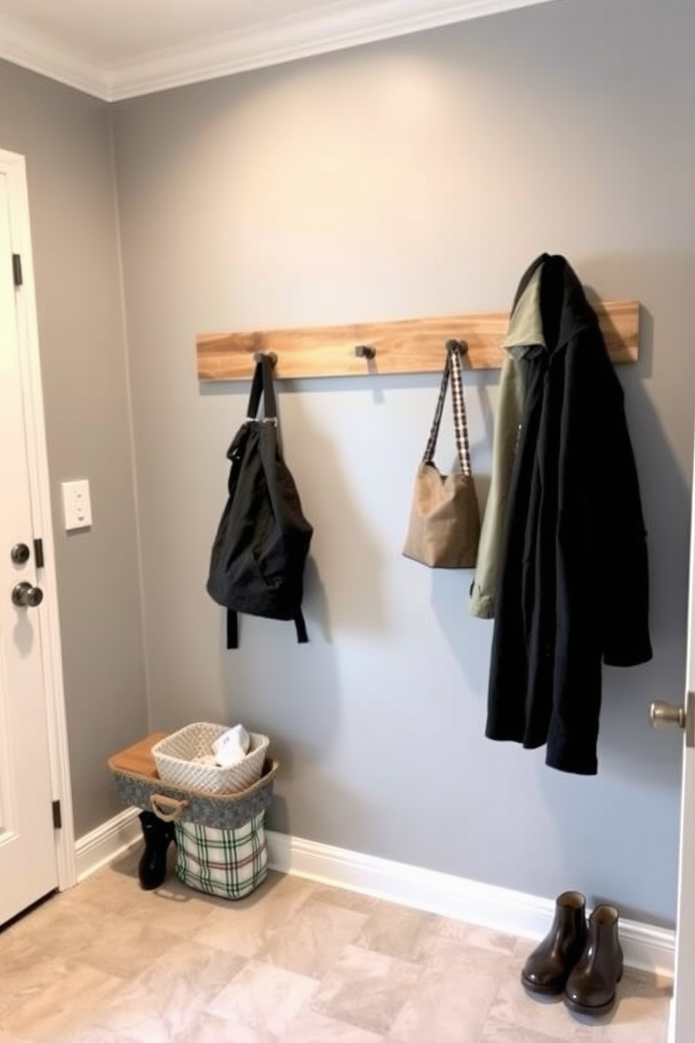 A stylish mudroom featuring a wall-mounted coat rack made of natural wood for easy access. The walls are painted in a soft gray hue, complemented by a durable tile floor in a light beige tone.