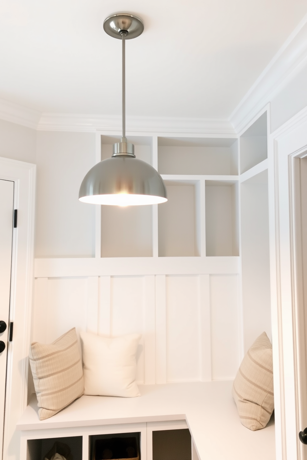 Chic pendant lighting for stylish illumination. The pendant lights feature a modern design with a sleek metallic finish and soft, warm bulbs that create an inviting atmosphere. White mudroom design ideas. The space includes built-in benches with plush cushions, open cubbies for storage, and a shiplap accent wall painted in a bright white hue.