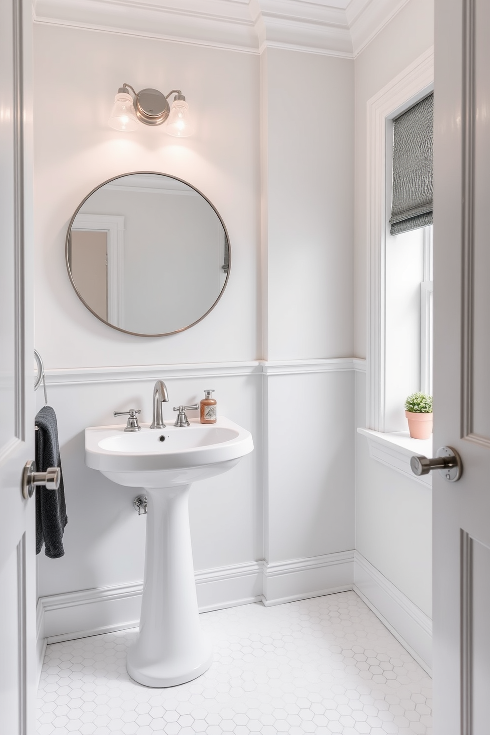 A chic powder room featuring soft gray accents that provide a subtle contrast against the crisp white walls. The space includes a sleek pedestal sink with a polished chrome faucet and a large round mirror framed in brushed nickel. The floor is adorned with delicate white hexagonal tiles that add texture while maintaining a clean aesthetic. A small potted plant sits on the windowsill, bringing a touch of greenery to the serene environment.