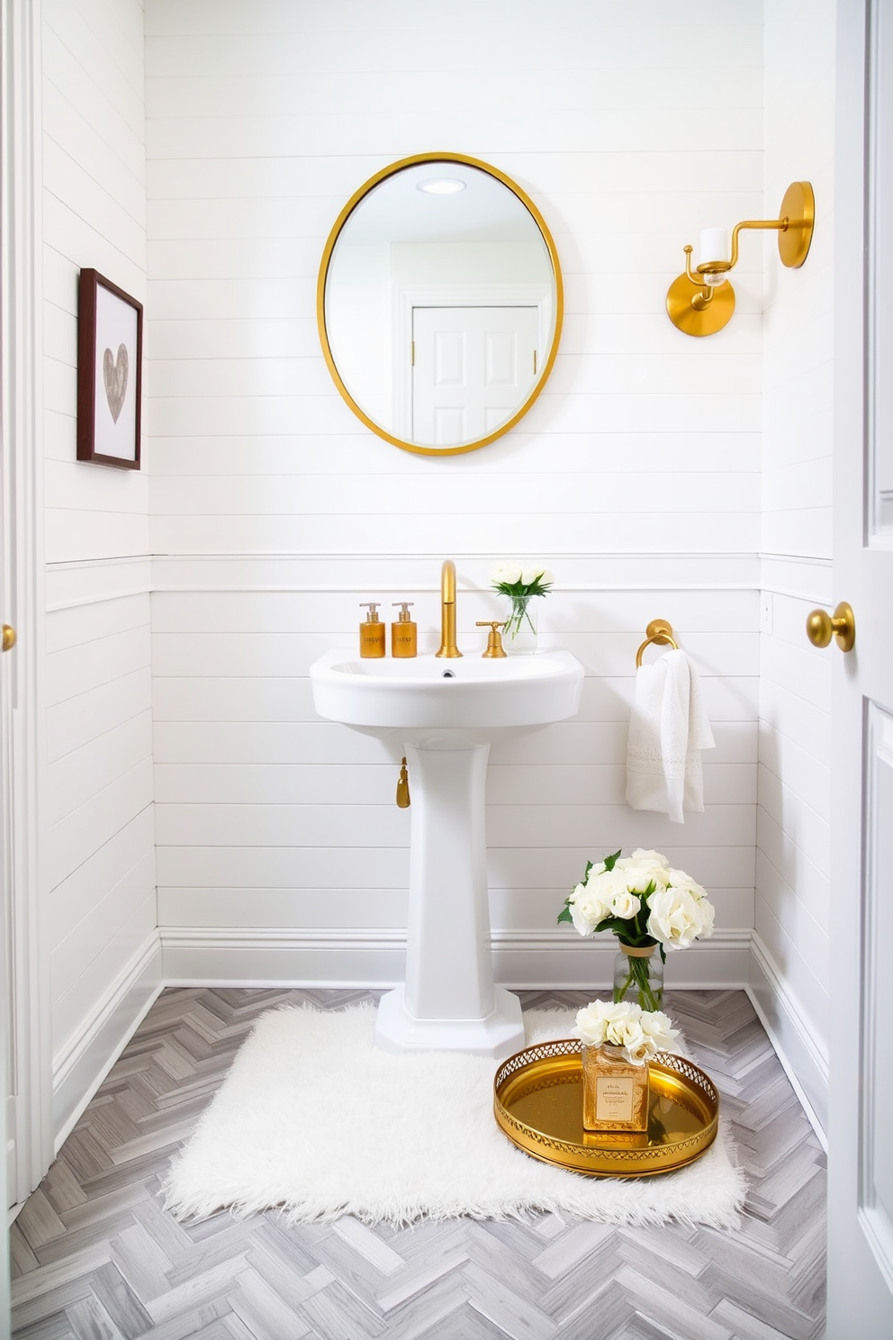 Chic white shiplap walls create a fresh and inviting atmosphere in this elegant powder room. Gold accents are strategically placed throughout the space, adding a touch of luxury and sophistication. A sleek white pedestal sink sits against the shiplap backdrop, complemented by a stylish gold faucet. Above the sink, a round gold-framed mirror enhances the room's brightness and elegance. The flooring features a light gray herringbone pattern, providing a subtle contrast to the white walls. A plush white rug lies beneath the sink, adding warmth and comfort to the space. Decorative elements include a small gold tray holding elegant hand soap and a fresh bouquet of white flowers. Soft ambient lighting from a gold wall sconce creates a welcoming glow in the evening.