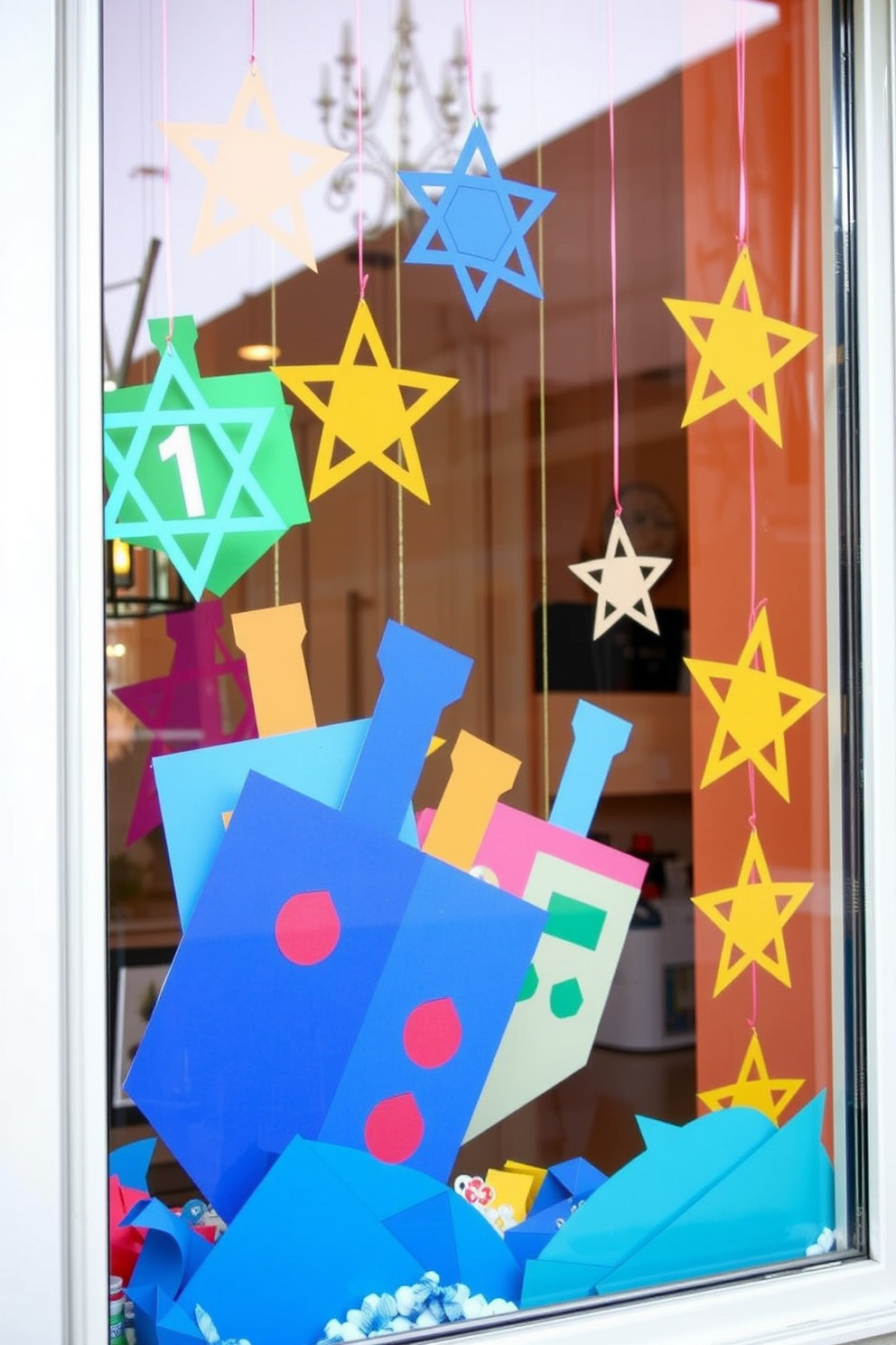 Create a festive window display for Hanukkah featuring DIY paper cutouts of dreidels and stars. The scene should be vibrant and colorful, with the cutouts hanging at various heights to create depth and visual interest.