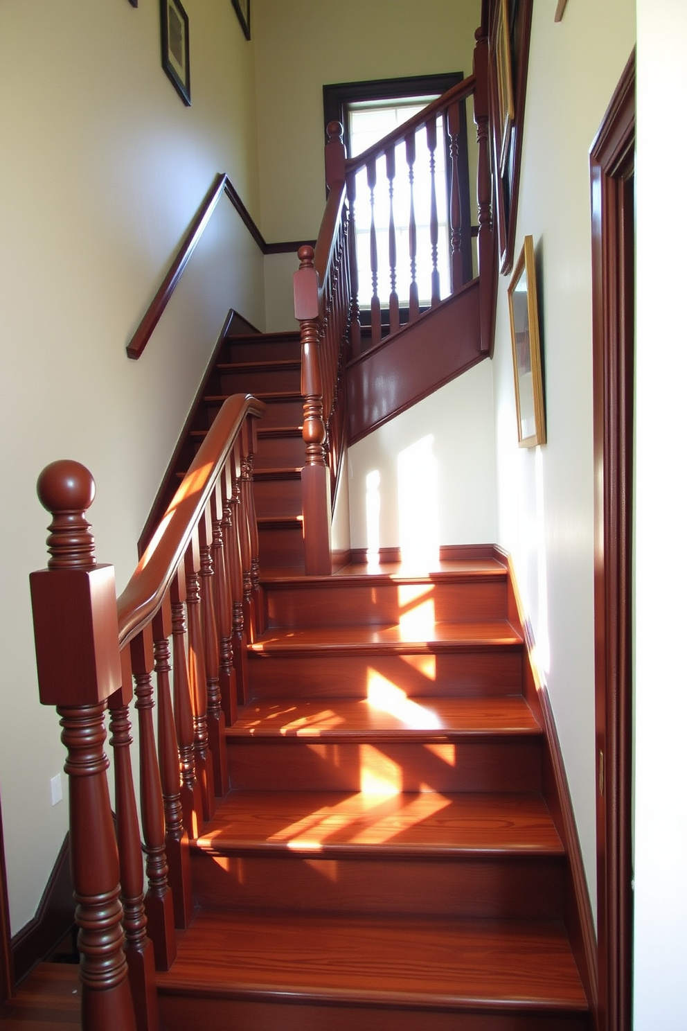 A traditional wooden staircase features elegant spindles and a polished handrail. The steps are crafted from rich mahogany, showcasing a warm and inviting finish that complements the surrounding decor. Natural light pours in from a nearby window, illuminating the intricate details of the staircase. The walls are adorned with framed artwork, adding a personal touch to this classic architectural element.