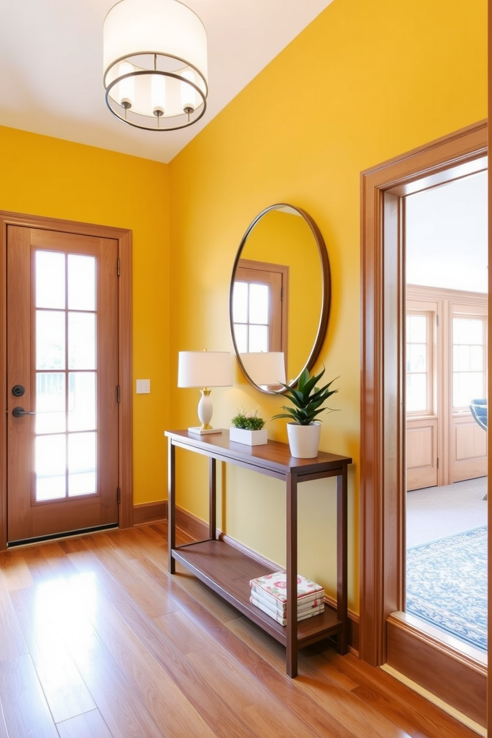 A bright and inviting foyer featuring a warm yellow accent wall that complements the natural wood tones of the flooring and trim. A sleek wooden console table is positioned against the wall, adorned with a stylish lamp and a small potted plant for a touch of greenery. The space is illuminated by a modern chandelier that adds elegance while enhancing the cheerful atmosphere. A large round mirror hangs above the console, reflecting the light and making the area feel more spacious and welcoming.