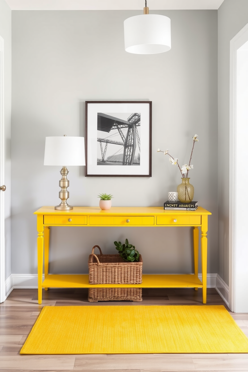 A vibrant yellow console table is positioned against a soft gray wall, adorned with decorative accents such as a stylish lamp and a framed artwork. Below the table, a woven basket adds texture and functionality, while a small potted plant brings a touch of greenery to the space. The foyer features a bright and welcoming atmosphere, with a yellow area rug anchoring the design. Soft lighting from a nearby pendant fixture enhances the cheerful vibe, creating an inviting entryway that leaves a lasting impression.