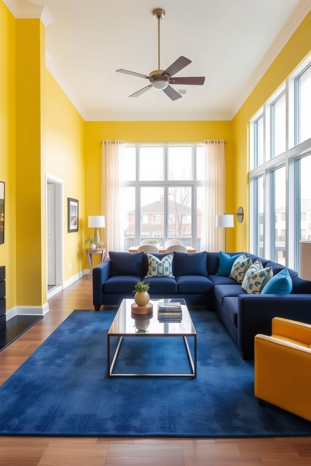 A bright and inviting living room featuring a blend of yellow and blue accents. The walls are painted a soft yellow, complemented by a navy blue sectional sofa adorned with vibrant throw pillows. A large area rug in shades of blue anchors the space, while a sleek coffee table sits at the center. Floor-to-ceiling windows allow natural light to flood the room, enhancing the cheerful atmosphere.