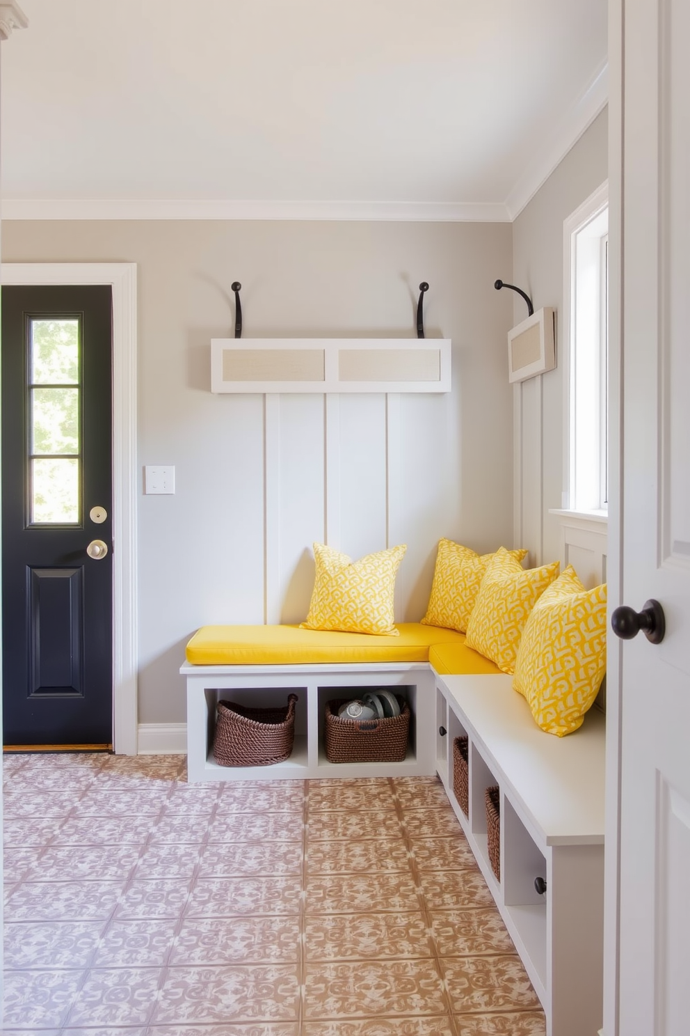 A bright and cheerful mudroom features a bench with bright yellow cushions for added comfort. The walls are painted in a soft gray tone, and the floor is adorned with patterned tiles that complement the vibrant cushions.