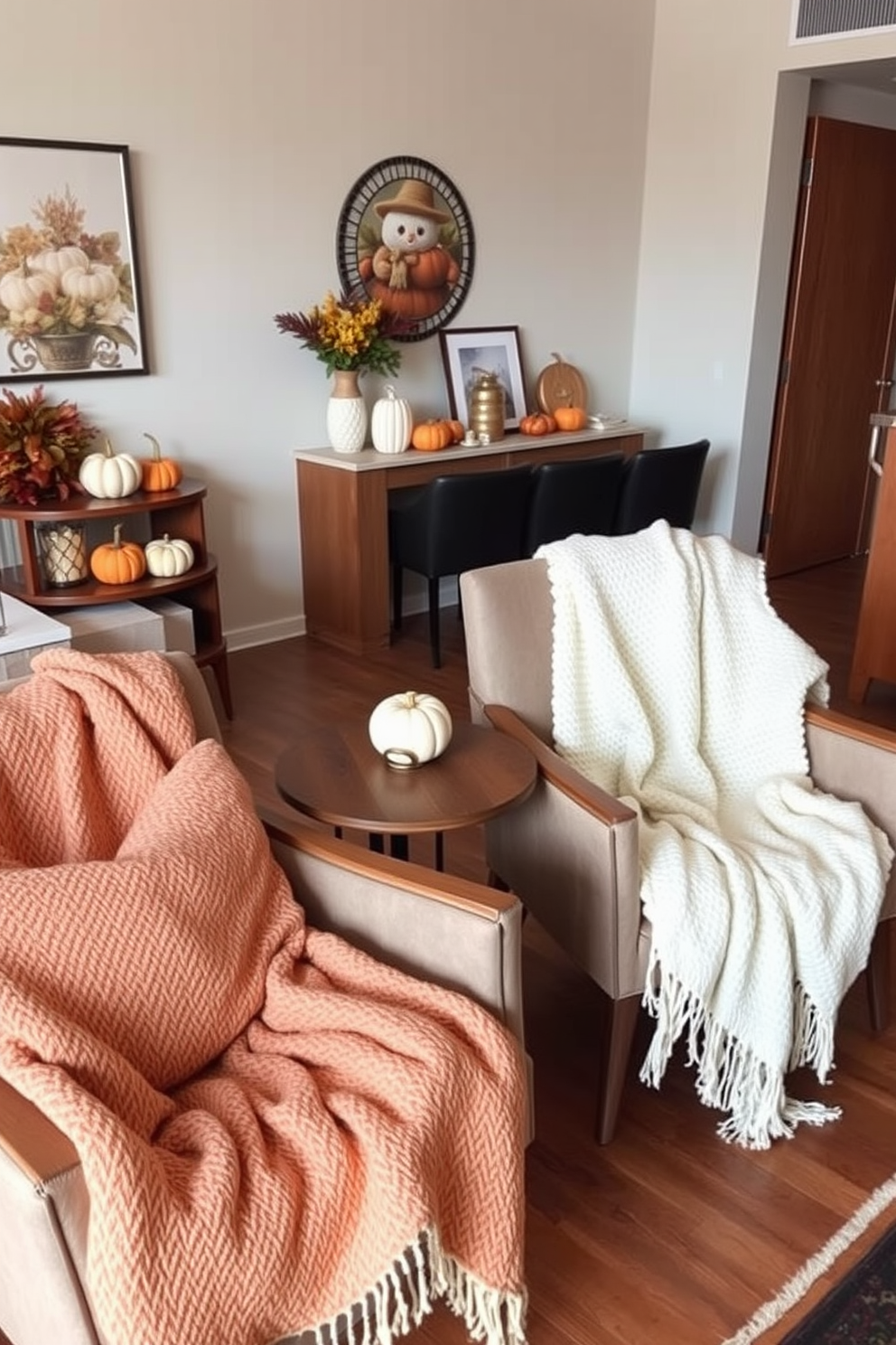 A cozy apartment living area featuring warm throw blankets draped over stylish chairs. The space is adorned with autumn-inspired decor, including pumpkins and earthy tones that evoke a sense of comfort and seasonal charm.