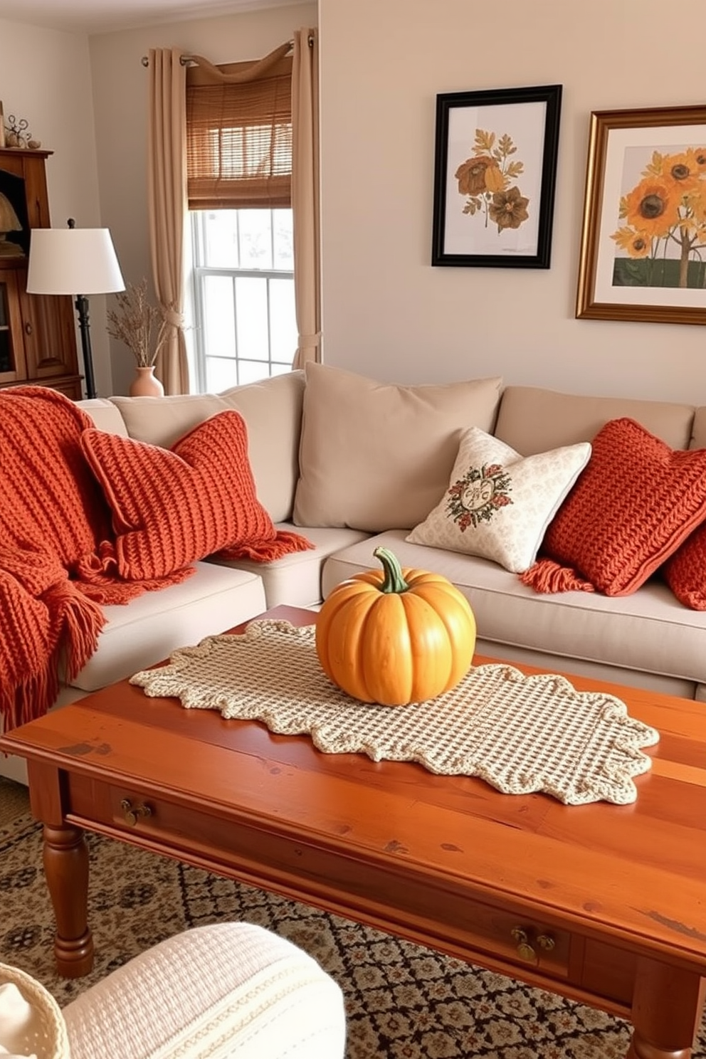 A cozy living room adorned with knitted items. Soft throw blankets and decorative pillows in warm autumn hues are draped over the sofa, inviting relaxation. A wooden coffee table is topped with a knitted table runner and a pumpkin centerpiece. The walls are decorated with framed autumn-themed artwork, enhancing the seasonal atmosphere.