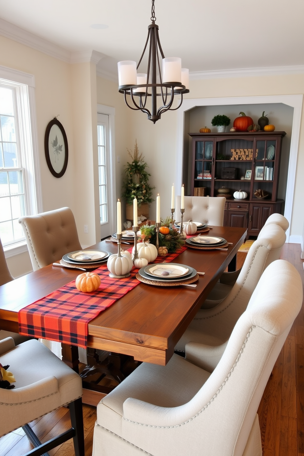 A warm and inviting dining room featuring a rustic wooden table set for a fall gathering. The table is adorned with warm plaid table runners in shades of orange, red, and yellow, complemented by an assortment of seasonal decorations like pumpkins and candles. Surrounding the table are comfortable upholstered chairs in earthy tones, creating a cozy atmosphere. The walls are painted in a soft cream color, and large windows allow natural light to fill the space, enhancing the inviting fall aesthetic.