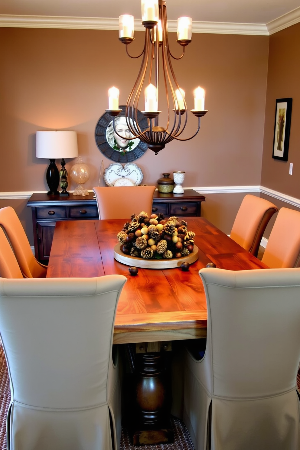 A warm and inviting dining room features a rustic wooden table adorned with a centerpiece of acorns and pinecones. Surrounding the table are elegant upholstered chairs in earthy tones, complementing the natural decor. Soft, ambient lighting from a chandelier above casts a cozy glow over the space, enhancing the autumnal theme. The walls are painted in a warm taupe, while a woven rug underfoot adds texture and comfort.