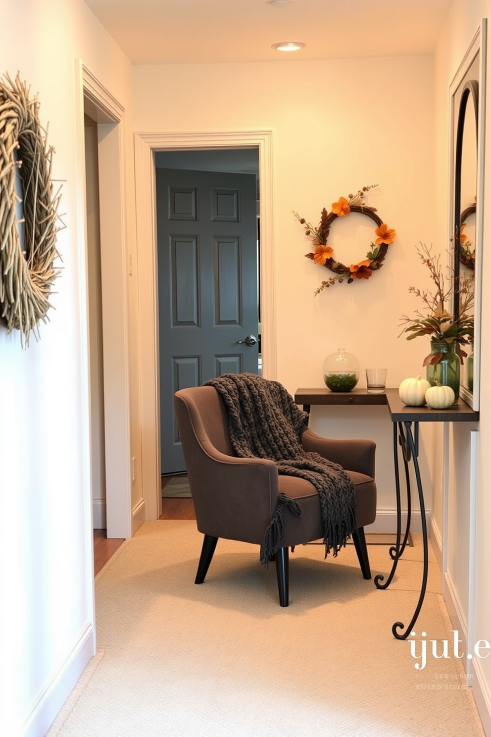 A cozy hallway features warm lighting and soft textures. A knitted throw is elegantly draped over a stylish chair, inviting relaxation and comfort. The walls are adorned with seasonal decor, showcasing autumn colors and natural elements. A small console table holds decorative pumpkins and a scented candle, enhancing the inviting atmosphere.