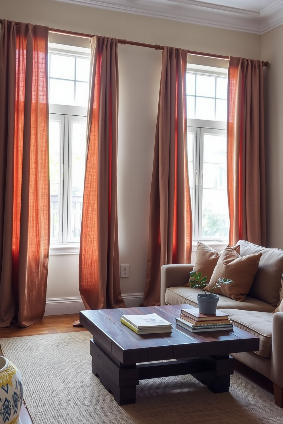 Earthy toned curtains drape elegantly from a wooden rod framing the windows allowing soft natural light to filter into the space. The small living room features a cozy arrangement of a plush sofa and a rustic coffee table adorned with a few decorative books and a potted plant.