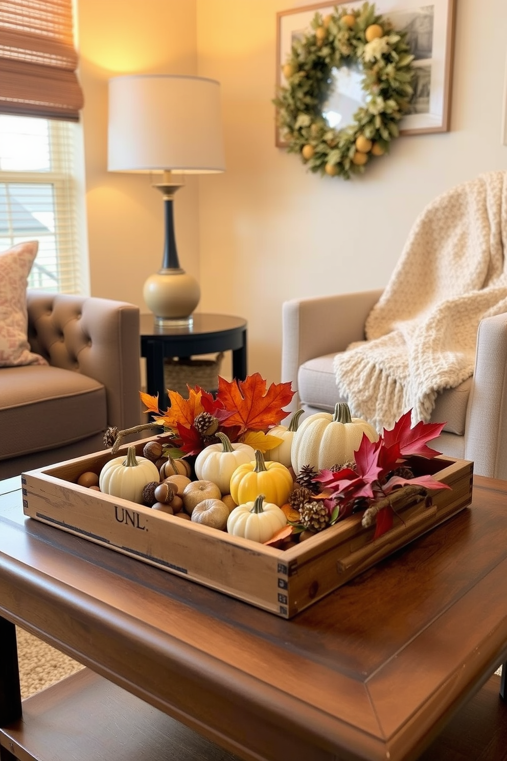 A cozy small space decorated for fall features a decorative tray on a coffee table filled with seasonal items such as mini pumpkins, acorns, and vibrant autumn leaves. Soft, warm lighting enhances the inviting atmosphere, while a plush throw blanket drapes over the arm of a nearby chair.