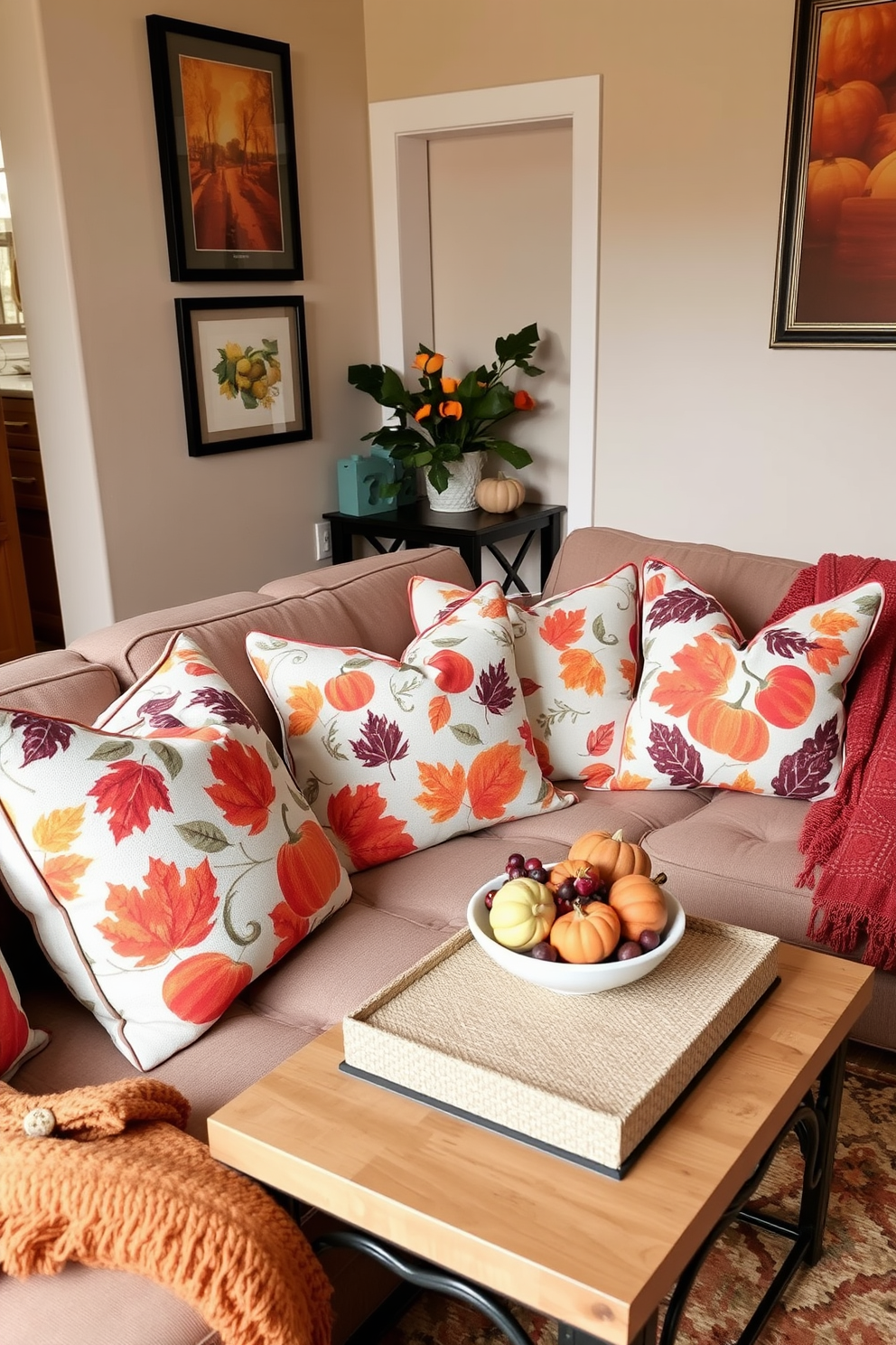 A cozy living room featuring a collection of throw pillows adorned with vibrant fall patterns such as leaves and pumpkins. The pillows are arranged on a snug sofa, complemented by a warm throw blanket draped over the armrest. A charming small space designed for autumn, with a compact coffee table showcasing a centerpiece of seasonal decor. The walls are adorned with warm-toned artwork, and a decorative rug adds texture to the inviting atmosphere.