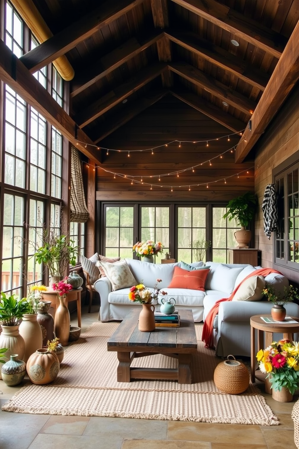 A charming farmhouse-style sunroom features rustic wooden beams overhead and large windows that let in ample natural light. The space is adorned with cozy furniture, including a plush sectional covered in soft linen and a reclaimed wood coffee table, surrounded by potted plants and vintage decor accents. Sunroom decorating ideas include layering textures with woven rugs and soft throw blankets in warm autumn colors. A collection of handmade ceramic vases filled with seasonal flowers adds a touch of nature, while fairy lights strung along the beams create a warm and inviting ambiance.