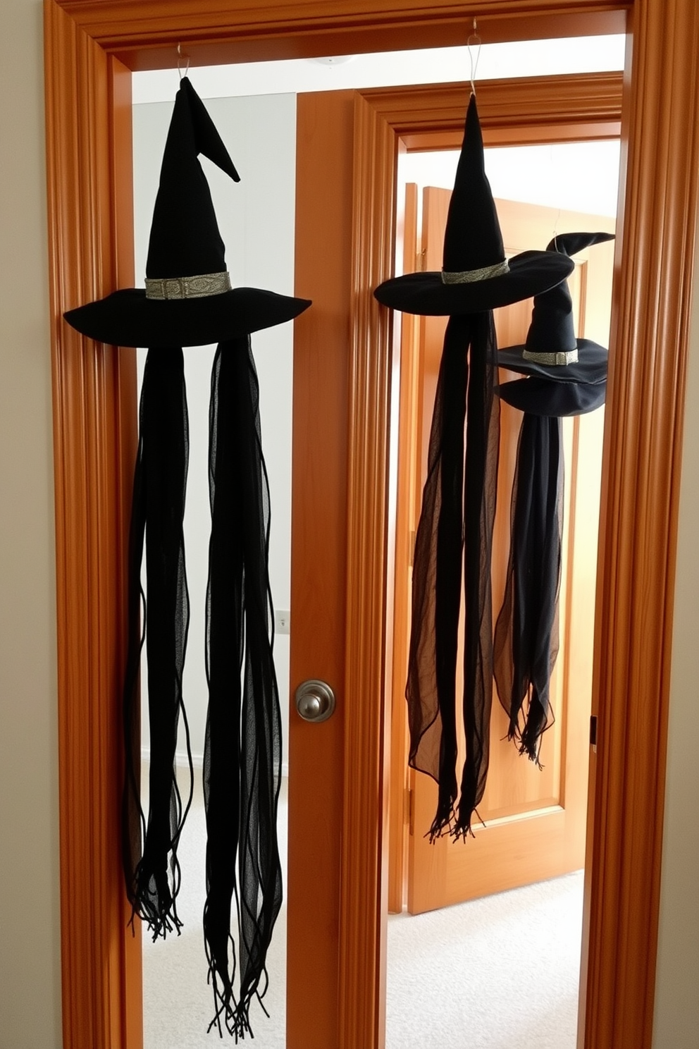 Hanging witch hats are draped elegantly from the door frames, creating a whimsical and festive atmosphere. The rich black fabric of the hats contrasts beautifully with the warm wood tones of the frames, enhancing the Halloween spirit in the apartment.