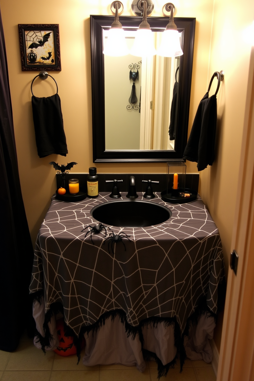 A spooky yet elegant Halloween bathroom setting. The sink area is adorned with a spider web tablecloth draping over the countertop, creating an eerie atmosphere. Black and orange decorative accents enhance the festive theme. A few strategically placed faux spiders crawl across the tablecloth, adding a playful touch to the decor.