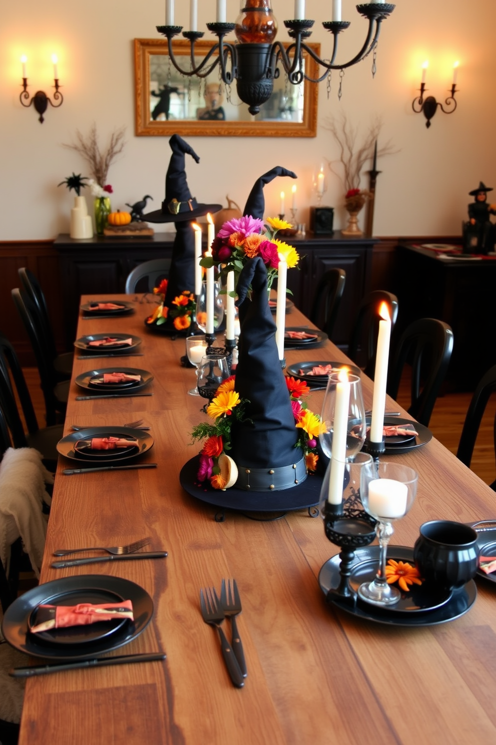 A whimsical dining room setting features a long wooden table adorned with witch hat centerpieces filled with vibrant seasonal flowers. The table is set with elegant black and orange tableware, and flickering candlelight adds a cozy ambiance to the Halloween theme.