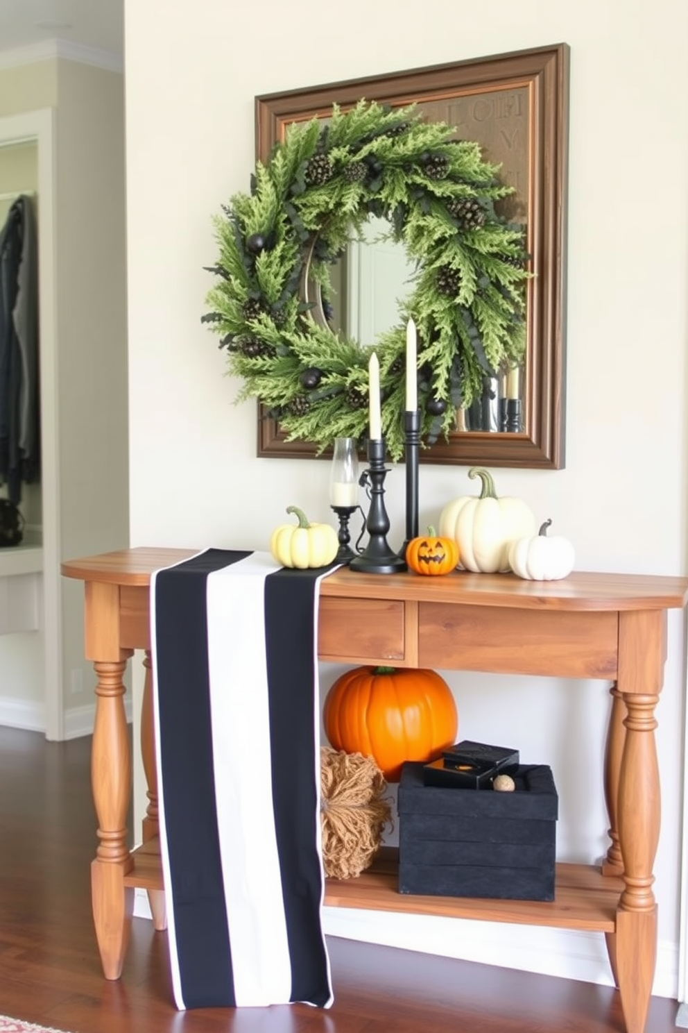 A stylish entryway featuring a black and white striped table runner elegantly draped across a rustic wooden console table. On the table, there are decorative pumpkins in varying sizes and a spooky candle arrangement that sets a festive Halloween mood.