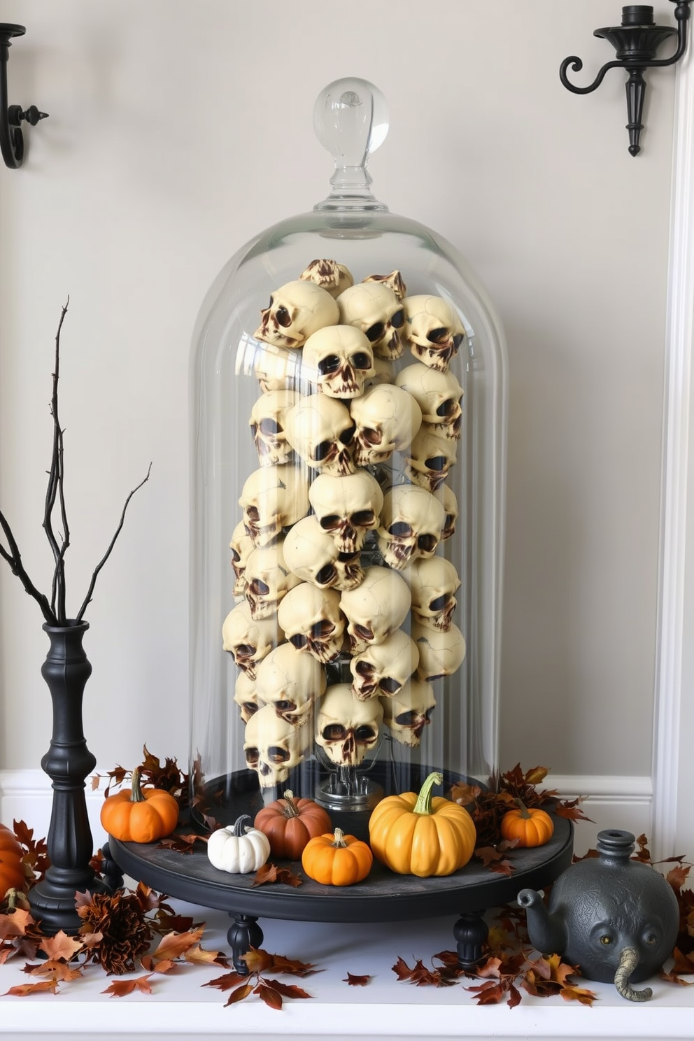 A striking Halloween entryway features a glass cloche filled with faux skulls, creating an eerie yet elegant focal point. Surrounding the cloche, autumnal decorations like miniature pumpkins and dried leaves enhance the seasonal theme.