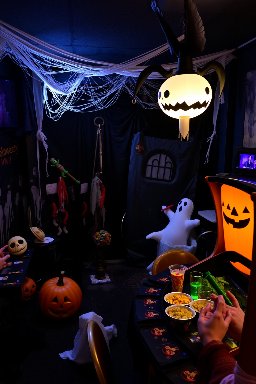 A creepy photo booth area is set up with dim lighting and eerie decorations. The backdrop features cobwebs, hanging bats, and a spooky graveyard scene, while a variety of Halloween props like masks and fake weapons are scattered around for guests to use. The game room is adorned with Halloween-themed decor, including inflatable ghosts and pumpkins. A themed table holds spooky snacks and drinks, creating an inviting yet chilling atmosphere for guests to enjoy.