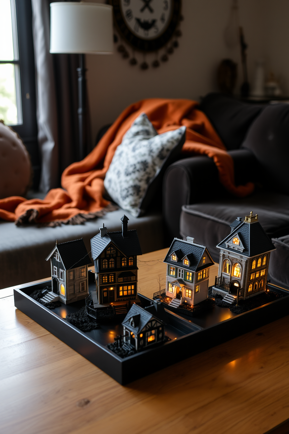 A cozy living room adorned with miniature haunted houses as decor for Halloween. The room features a plush sofa draped with an orange and black throw blanket, while small haunted houses sit on the coffee table, each illuminated with flickering LED lights.