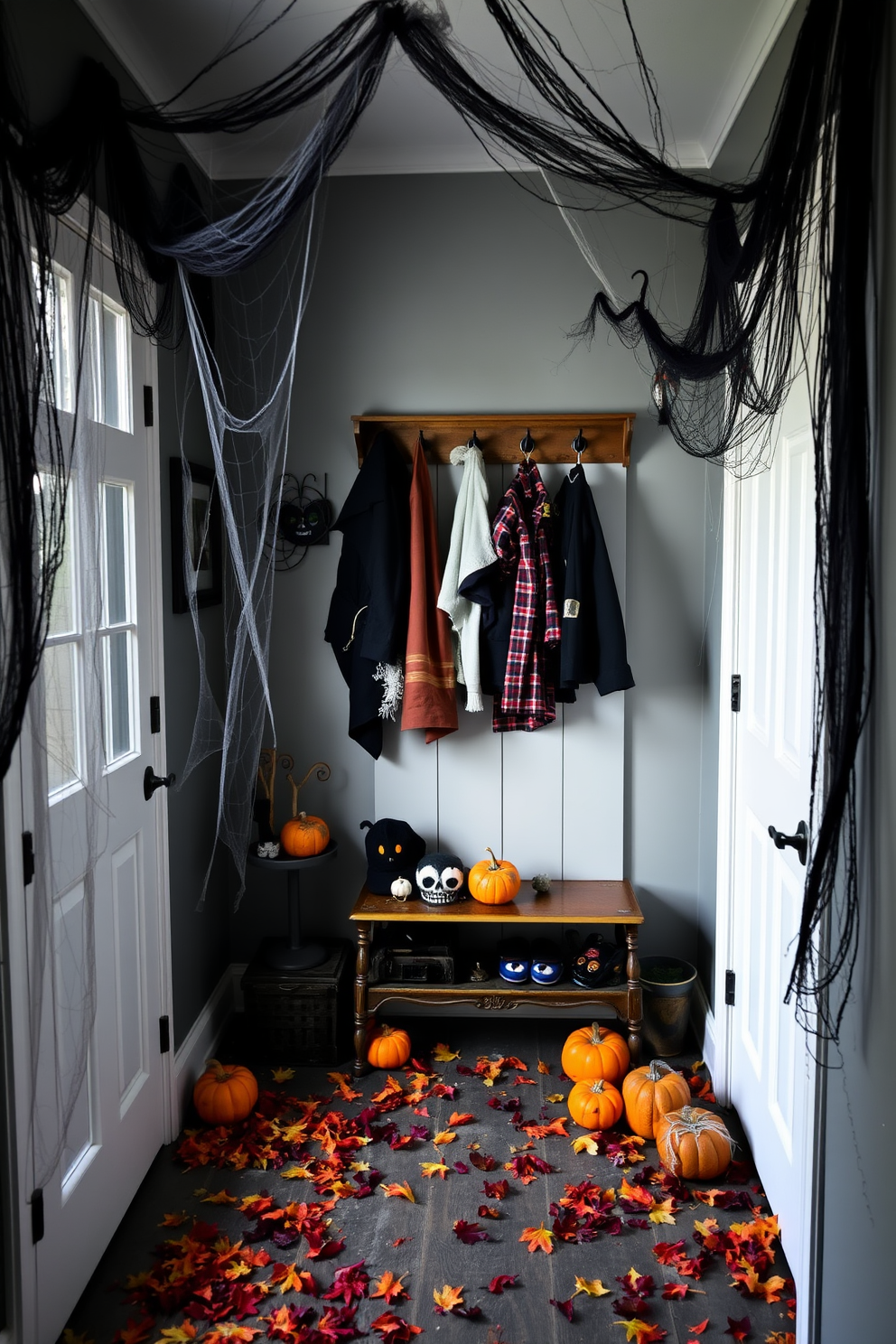 A spooky mudroom decorated for Halloween features eerie cobwebs draping from the corners, creating a chilling atmosphere. The floor is scattered with fake leaves and small pumpkins, while a vintage coat rack holds a mix of costumes and spooky accessories.