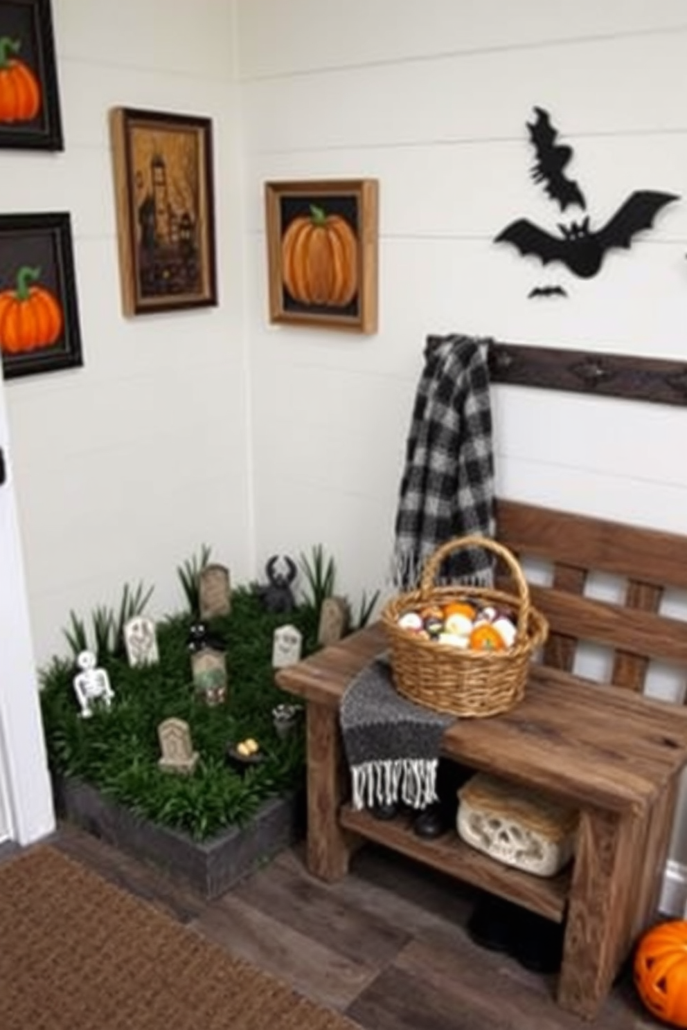 A whimsical miniature graveyard scene is set up in the corner of a cozy mudroom. Small tombstones are scattered among artificial grass, with spooky decorations like ghosts and skeletons peeking from behind the stones. The walls of the mudroom are adorned with Halloween-themed artwork, including pumpkins and bats. A rustic bench is placed against the wall, decorated with a festive throw and a basket filled with seasonal treats.