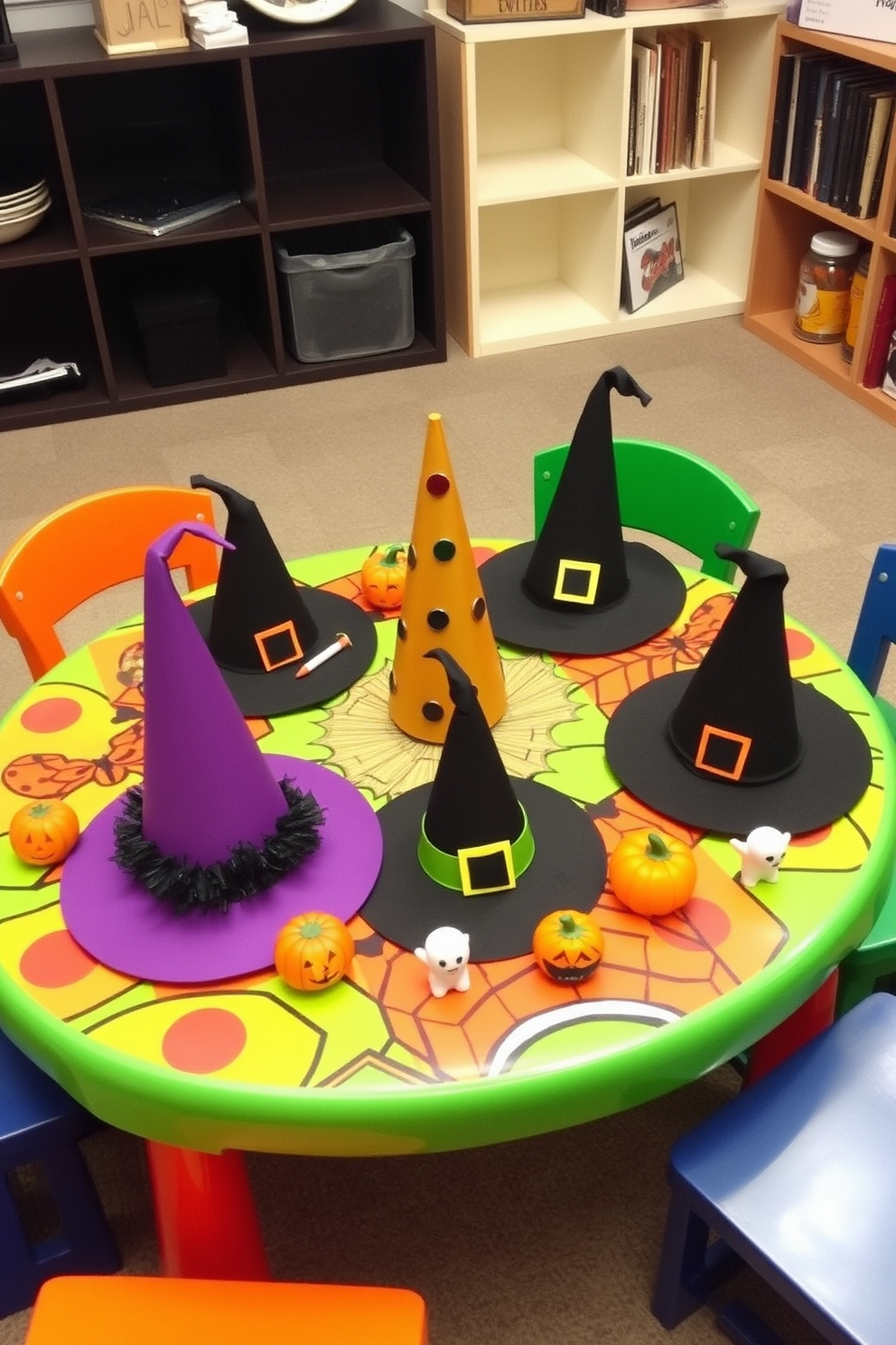 Witch hats in various sizes are arranged as centerpieces on a colorful play table designed for Halloween. Surrounding the hats are playful decorations like mini pumpkins and ghost figurines, creating a festive atmosphere in the playroom.