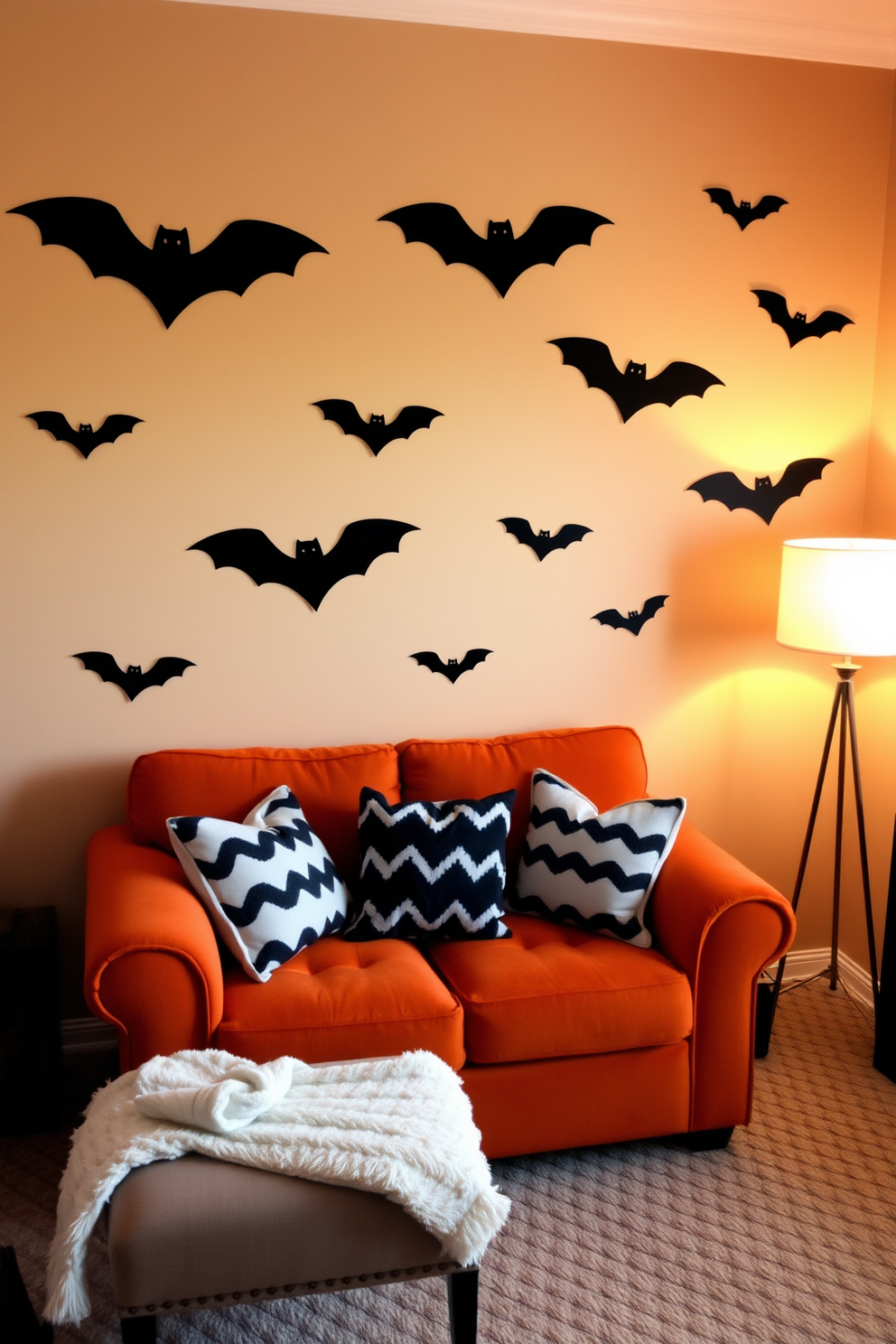 A cozy small living room decorated for Halloween features playful bat-shaped wall decals that add a whimsical touch to the space. The walls are painted in a warm neutral tone, allowing the black bats to stand out and create a festive atmosphere. A plush orange sofa is adorned with black and white throw pillows, enhancing the seasonal theme. Soft lighting from a stylish floor lamp casts a warm glow, making the room feel inviting and perfect for entertaining guests.