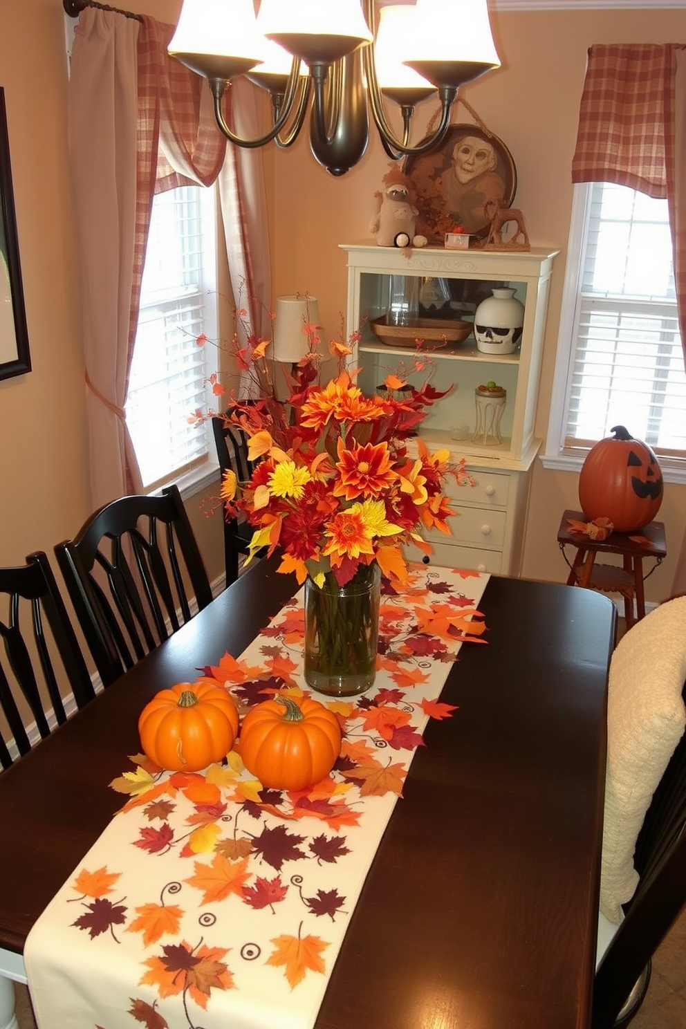 A cozy dining area decorated for Halloween features a themed table runner adorned with pumpkins and autumn leaves. The small space is enhanced by warm lighting and a centerpiece of seasonal flowers in rich, earthy tones.