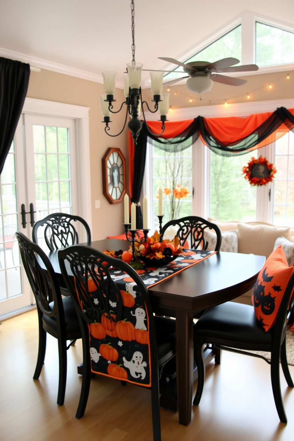 A dining table adorned with a Halloween-themed table runner featuring pumpkins and ghosts. Surrounding the table are elegant chairs with dark upholstery, and a centerpiece of candles and autumn leaves adds a festive touch. A sunroom decorated for Halloween with vibrant orange and black accents. Cozy seating is arranged with throw pillows featuring spooky patterns, and string lights create a warm, inviting atmosphere.