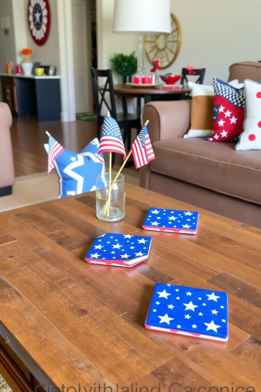 American flag themed coasters are placed on a rustic wooden coffee table. The coasters feature vibrant red and blue colors with white stars, perfectly complementing the festive atmosphere of the room. Surrounding the table, patriotic decorations such as small flags and themed cushions enhance the Independence Day spirit. The apartment is adorned with red, white, and blue accents, creating a welcoming and celebratory environment.