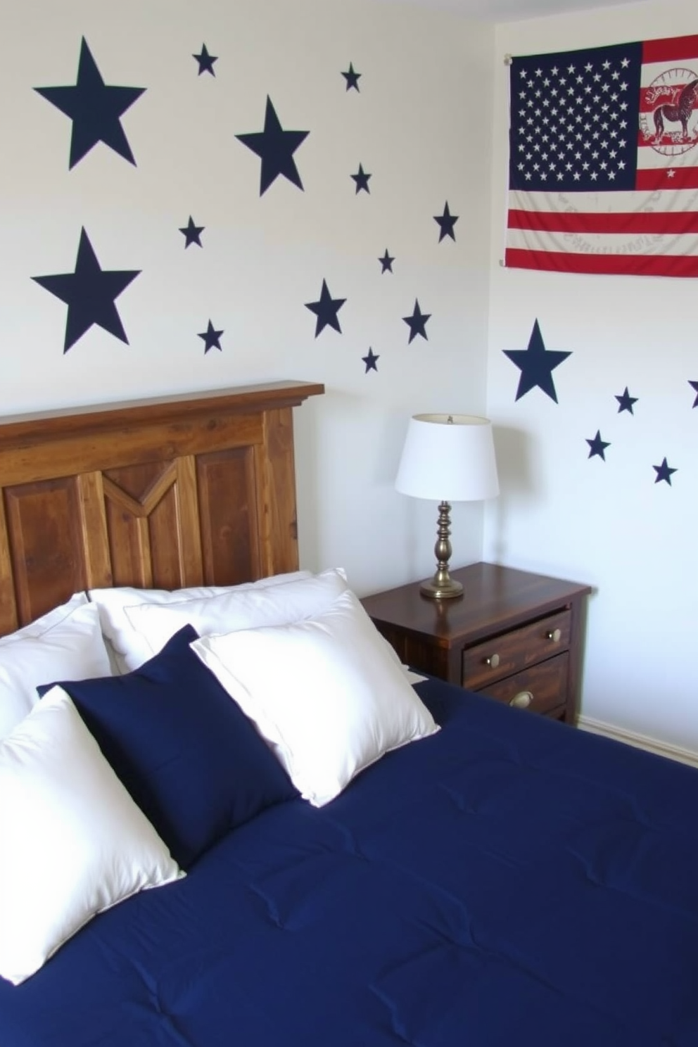 A cozy bedroom featuring wall decals of stars and stripes in a patriotic theme. The decor includes a navy blue bedspread with white pillows and a rustic wooden nightstand beside the bed.