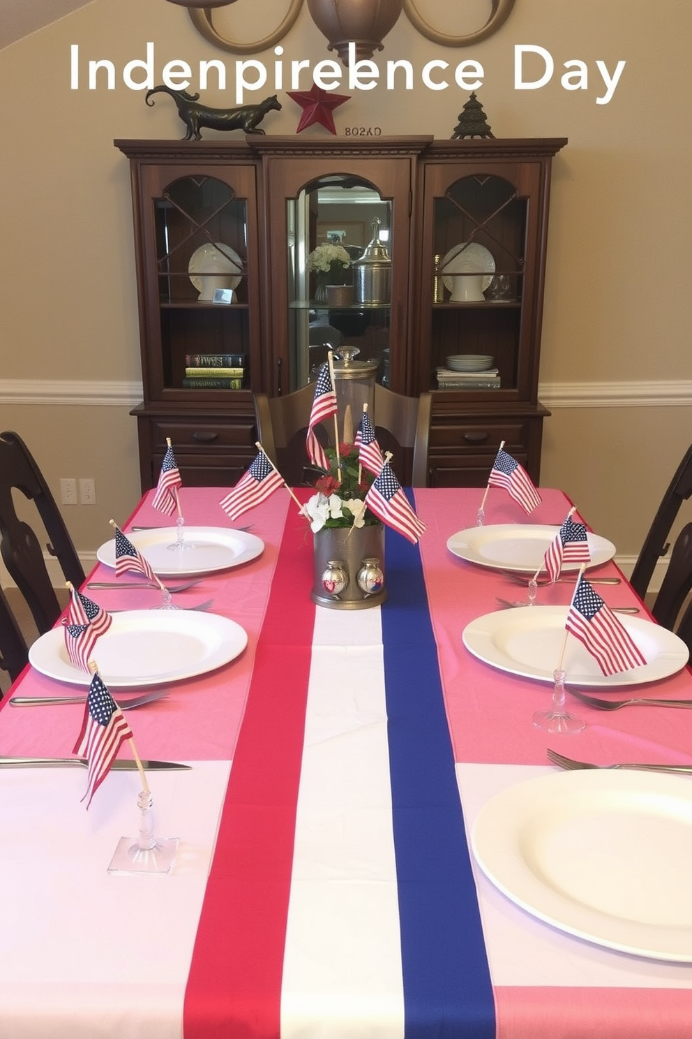 A festive dining room setting for Independence Day. Each place setting features a miniature flag adding a patriotic touch to the table. The table is adorned with a vibrant red, white, and blue tablecloth. Centered on the table is a decorative centerpiece with stars and stripes accents.