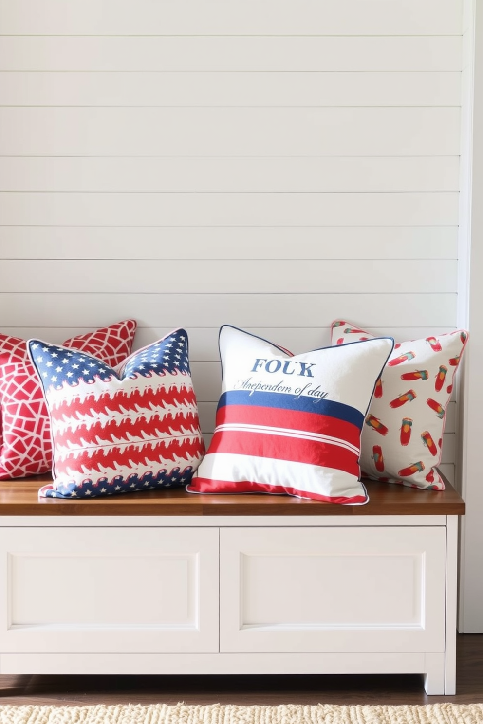 Festive throw pillows are arranged on a cozy entryway bench, showcasing vibrant red, white, and blue patterns that celebrate Independence Day. The bench is positioned against a backdrop of white shiplap walls, enhancing the cheerful and welcoming ambiance of the space.