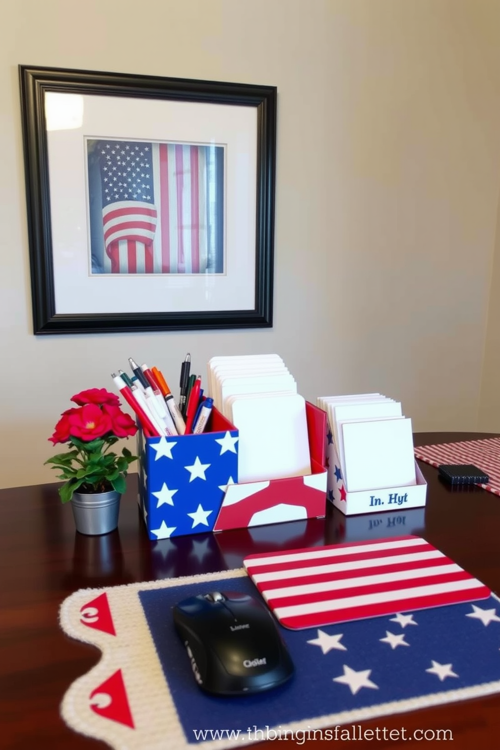 A home office decorated for Independence Day features desk accessories in red white and blue. The desk is adorned with a vibrant flag-themed organizer holding pens and notepads alongside a patriotic mouse pad. On the wall, a framed art piece showcases a classic Americana theme with stars and stripes. A small potted plant with red flowers sits next to a festive table runner that complements the overall decor.