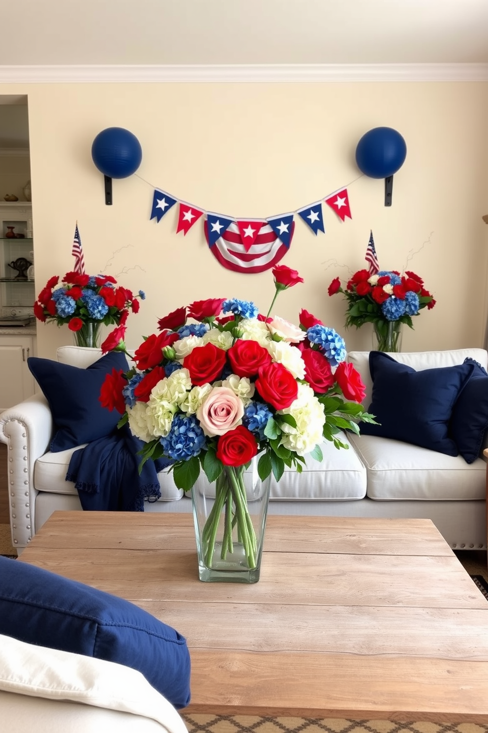 A vibrant living room adorned with red and blue floral arrangements celebrating Independence Day. The arrangement features a mix of fresh roses and hydrangeas in a large glass vase placed on a rustic wooden coffee table. The walls are painted in a soft cream color, creating a warm and inviting atmosphere. Cozy navy blue throw pillows are scattered on a light gray sofa, complementing the festive decor.