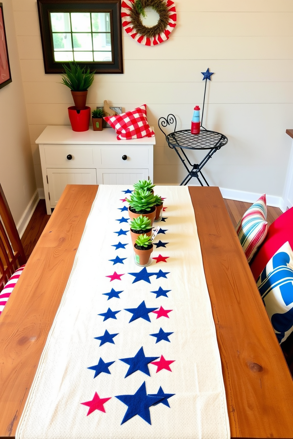 A patriotic table runner featuring stars stretches across a rustic wooden dining table. The table is adorned with small potted plants and red, white, and blue accents to celebrate Independence Day. In a cozy corner of the room, a small bistro set complements the festive decor. Brightly colored cushions add comfort while maintaining a cheerful atmosphere for summer gatherings.