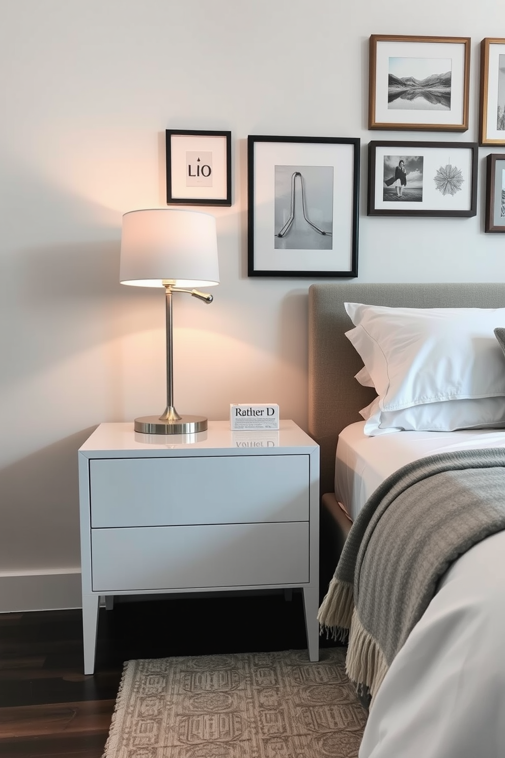 A chic bedside table is elegantly positioned next to a plush queen-sized bed adorned with soft linens. The table features a sleek design with a glossy finish and is topped with a stylish lamp that casts a warm glow. On the opposite wall, a gallery of framed art pieces adds personality to the space, complementing the soothing color palette of muted blues and whites. A cozy throw blanket is draped over the bed, inviting relaxation and comfort.