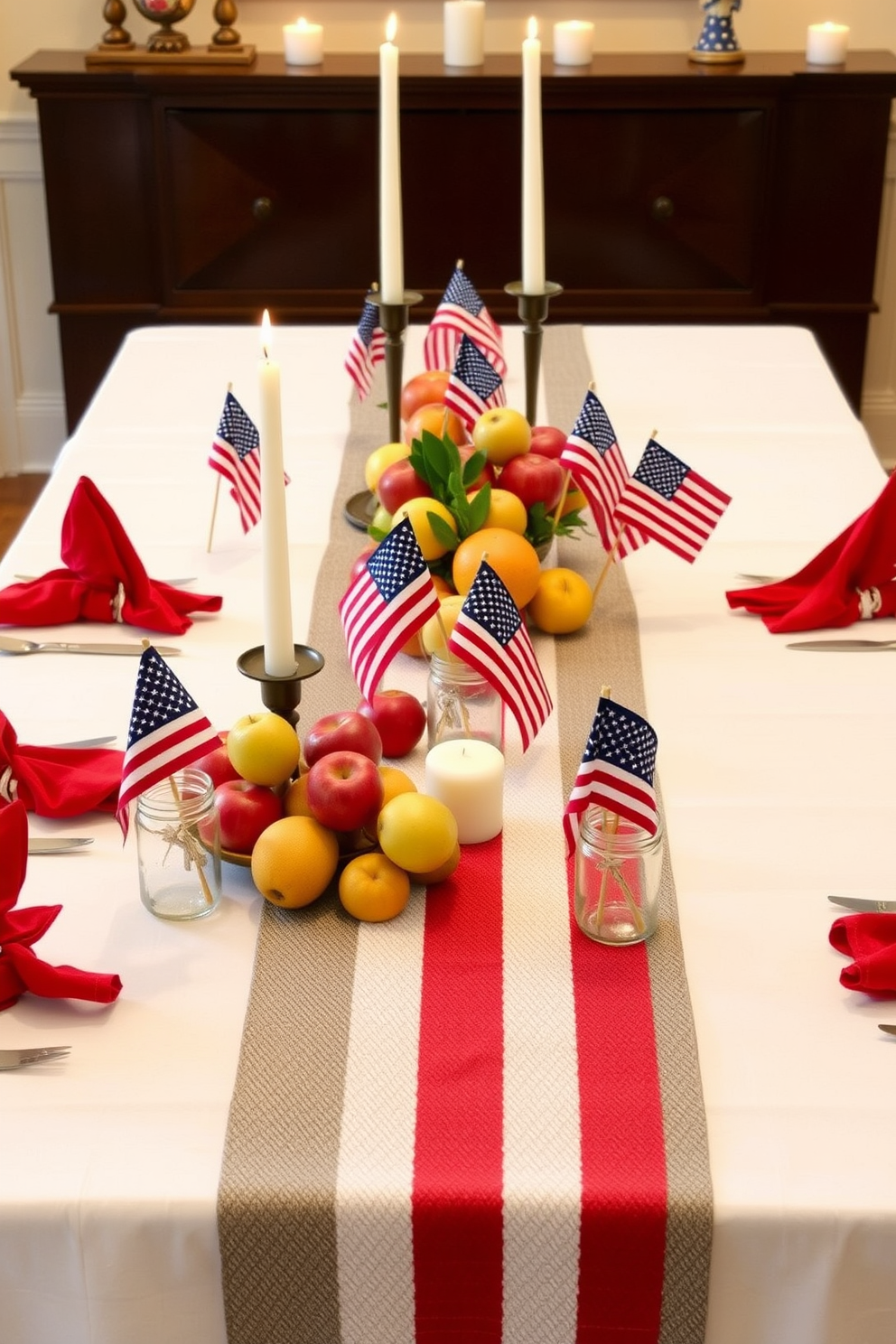 A festive table setting for Labor Day featuring a crisp white tablecloth. Mini American flags are placed in small mason jars as centerpieces, surrounded by red, white, and blue napkins folded elegantly at each setting. The table is adorned with a mix of seasonal fruits and a patriotic-themed runner. Candles in varying heights add warmth and ambiance to the celebration.