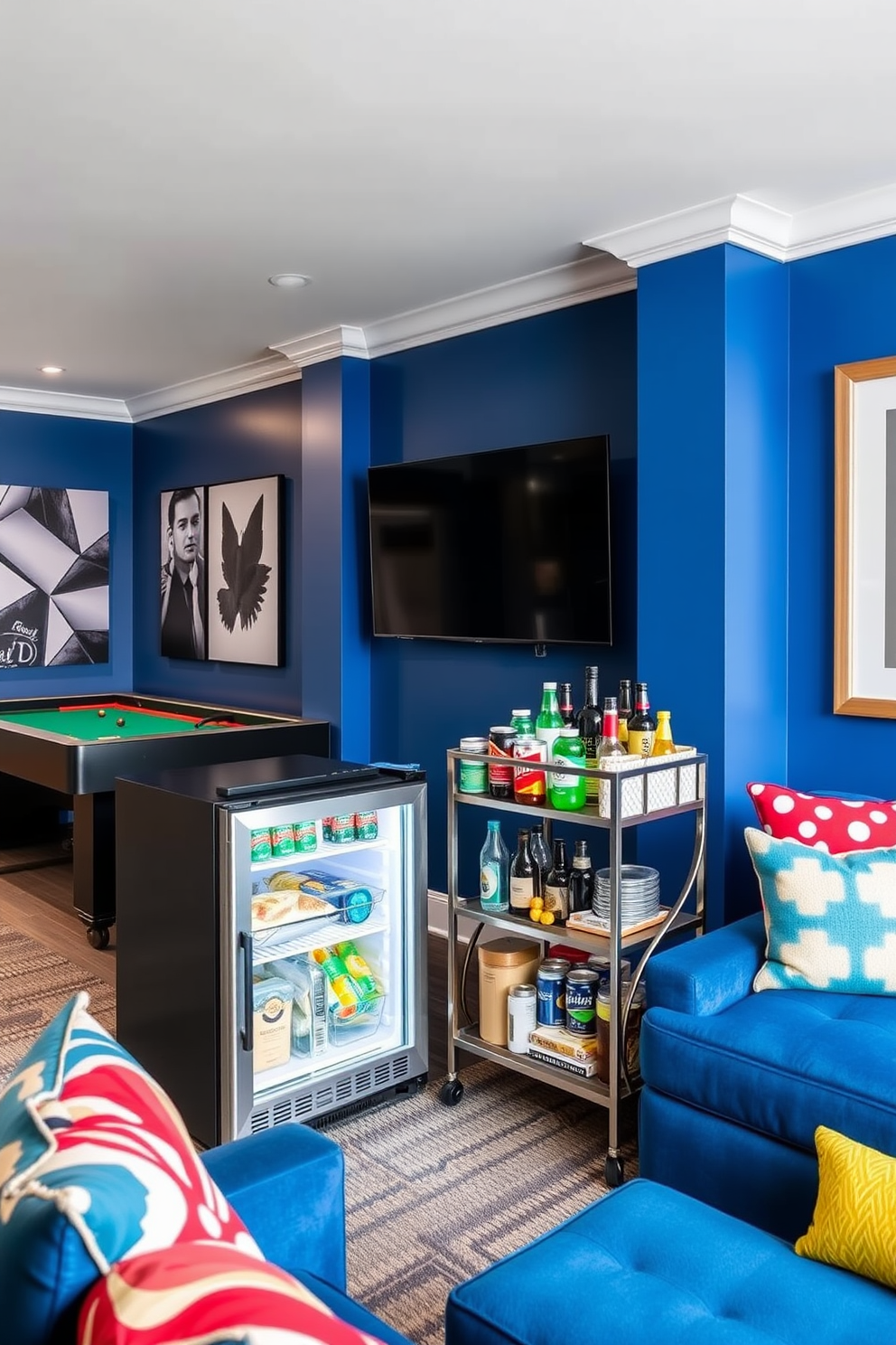 A modern game room featuring a sleek mini fridge dedicated to snacks and drinks. The fridge is positioned next to a stylish bar cart filled with various beverages and snacks for entertaining guests. The walls are painted in a vibrant blue, creating an energetic atmosphere. Plush seating arrangements with colorful cushions invite relaxation and enjoyment during game nights.