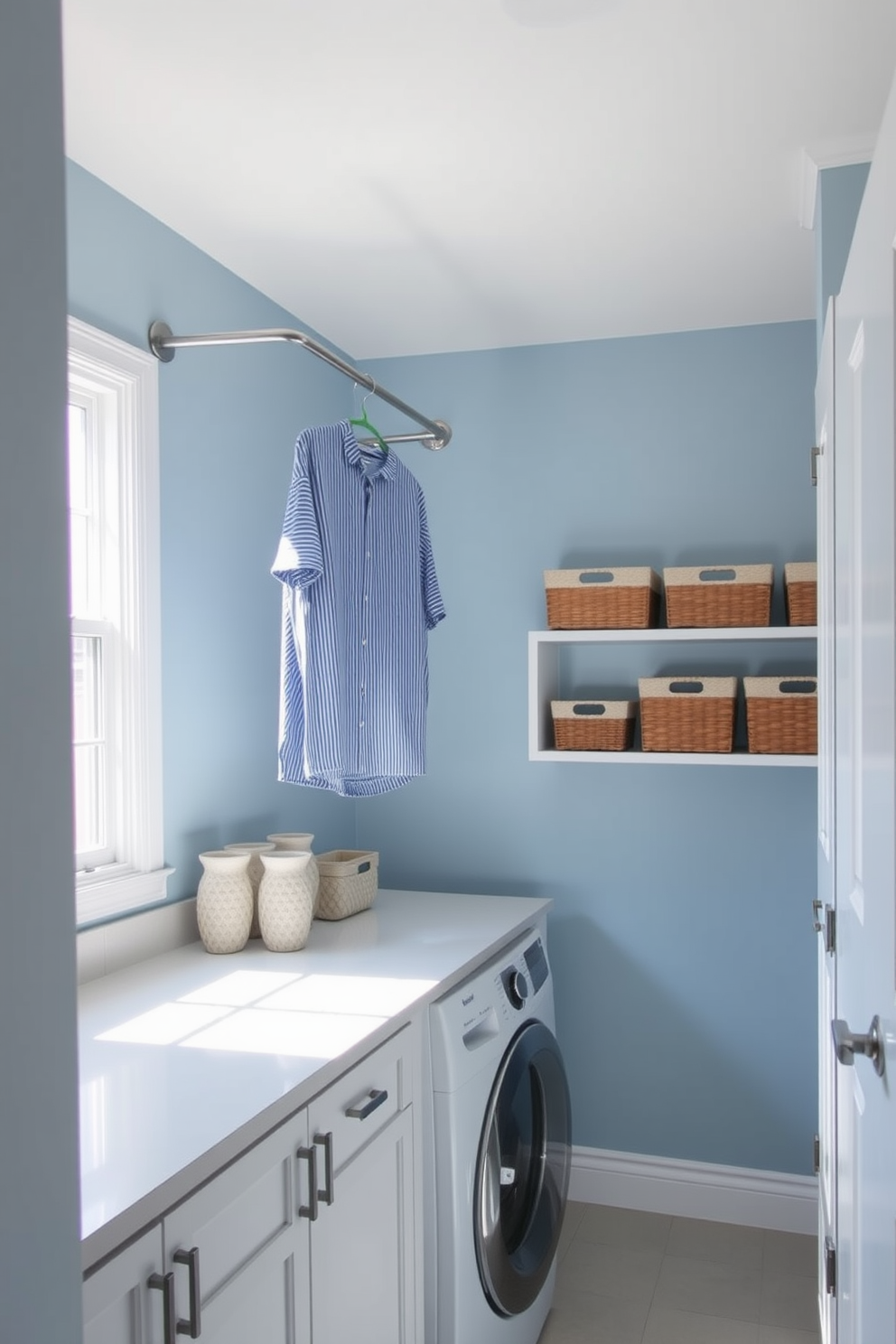 A functional laundry room featuring a hanging rod for clothes. The walls are painted in a soft blue hue, complemented by white cabinetry and a sleek countertop for folding laundry. Natural light streams in through a large window, illuminating the space. Decorative baskets are neatly arranged on the shelves, adding both style and storage.