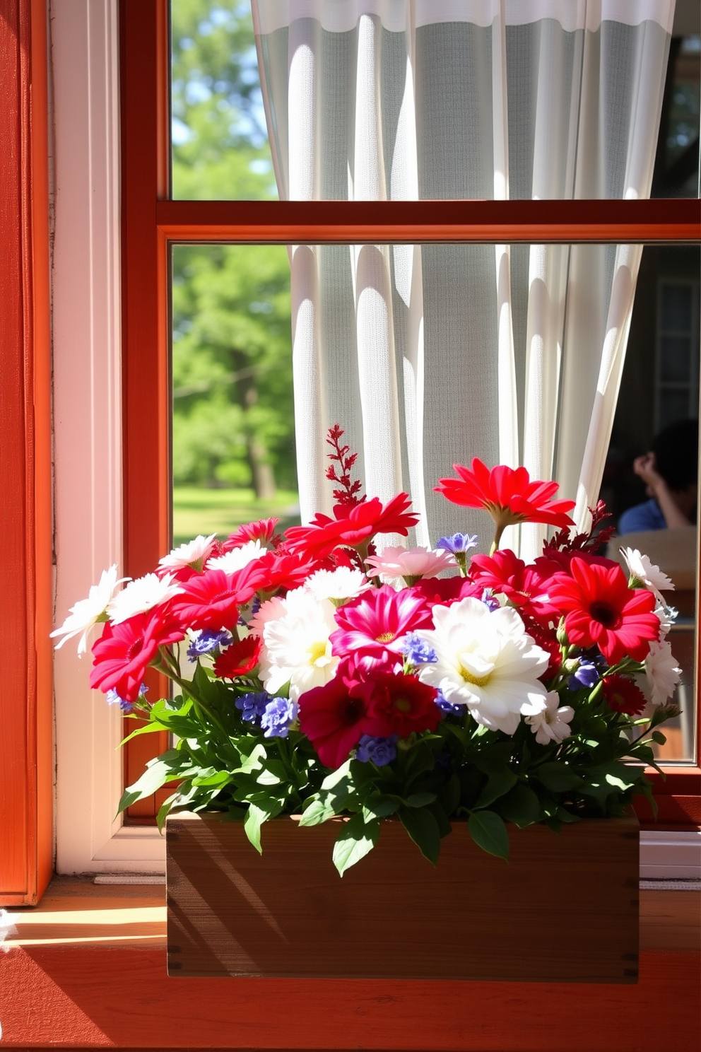 A bright and cheerful window display featuring seasonal flowers in vibrant shades of red, white, and blue. The flowers are arranged in a rustic wooden planter that complements the warm tones of the surrounding decor. Sunlight streams through the window, highlighting the fresh blooms and creating a welcoming atmosphere. A delicate sheer curtain gently sways in the breeze, adding a touch of elegance to the festive arrangement.