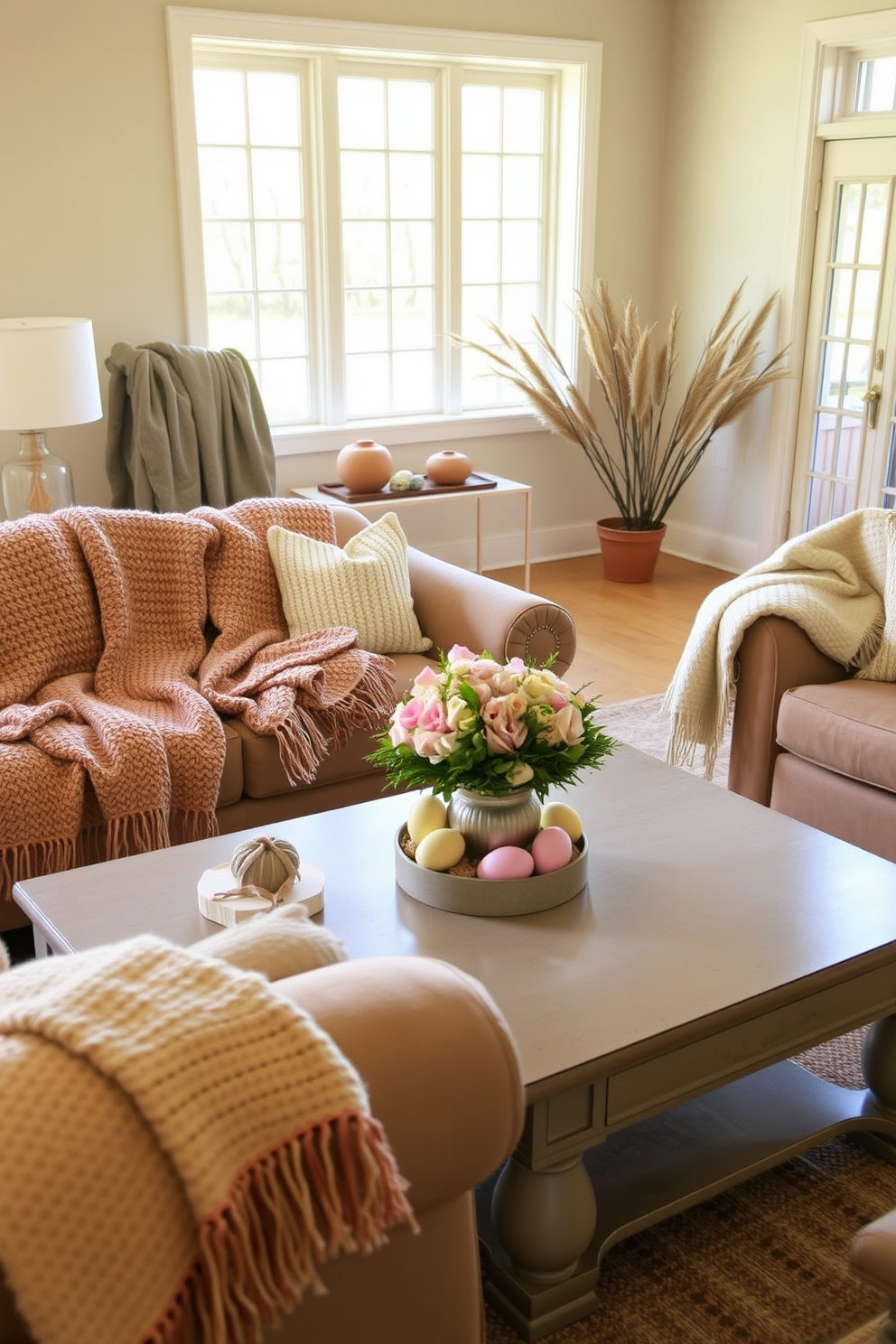 A cozy living room adorned with textured throws draped over a plush sofa and armchairs. The throws feature a mix of soft fabrics in warm tones, adding depth and comfort to the space. Easter decorations are tastefully arranged on the coffee table, including pastel-colored eggs and a floral centerpiece. The ambiance is inviting, with natural light streaming through large windows, enhancing the festive atmosphere.